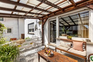 A covered outdoor seating area with a wooden table, a hanging chair, and a sofa with cushions. - Apartment 54 'Unit 1' with Private Terrace (Homberg (Efze))
