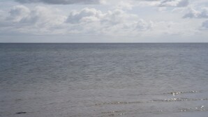 Un mar tranquilo bajo un cielo nublado.