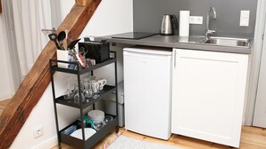 A compact kitchen with a white refrigerator, a stainless steel kettle, and a sink. - Apartment 'Mit Panoramablick' with Wi-Fi (Flensburg)