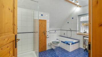 Ein Badezimmer mit Dusche, Toilette und Badewanne.