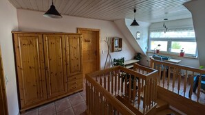 Una habitación amplia con un armario de madera, un escritorio y una ventana con vistas.