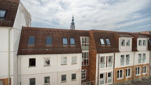 A row of residential buildings with a prominent tower in the background. - Apartment 'Top Location with Cathedral View' with Wi-Fi (Greifswald)