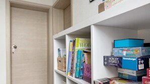 Uma estante com livros e jogos de tabuleiro.
