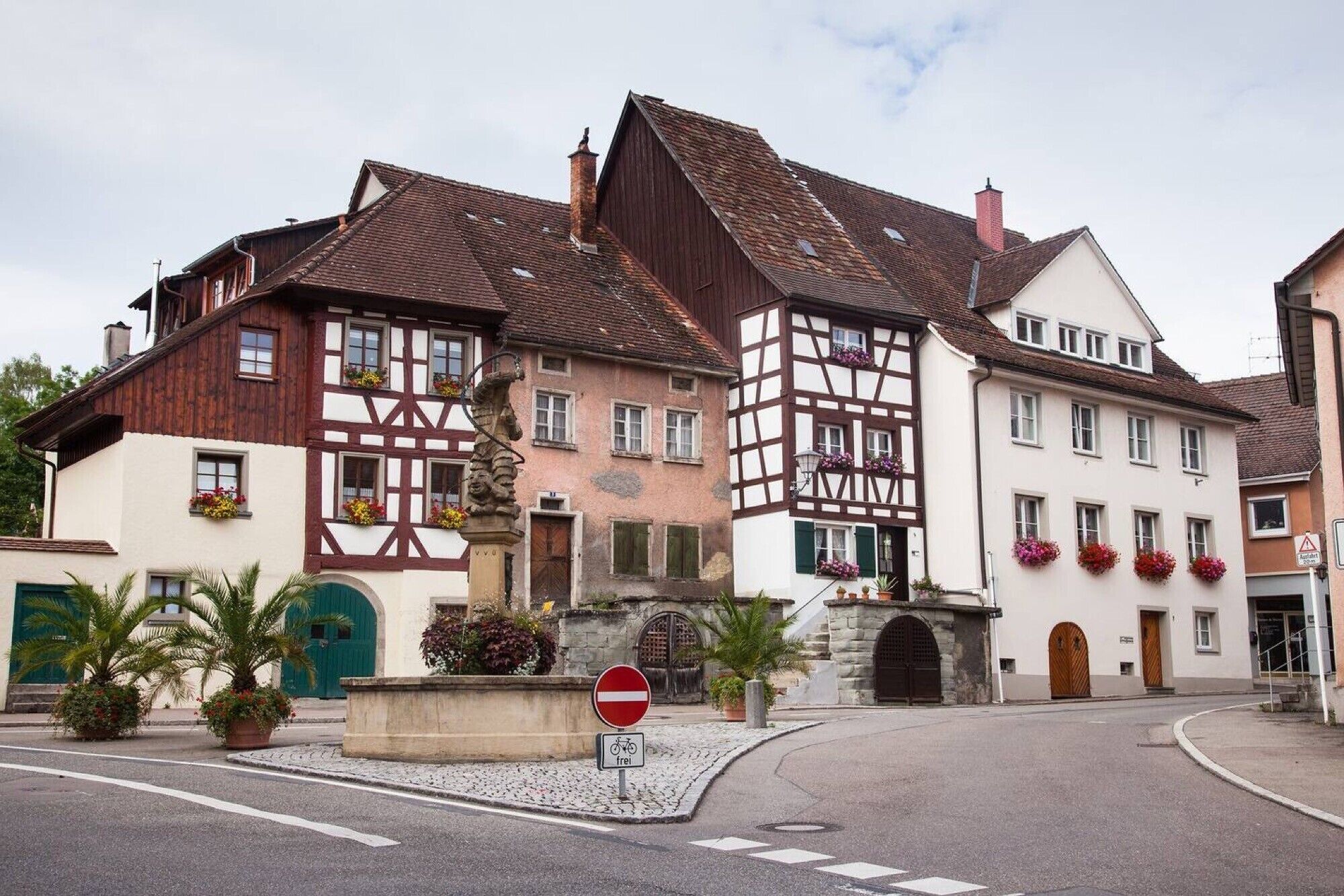 Une ville européenne typique, avec ses maisons à colombages, un panneau de signalisation indiquant une rue interdite à la circulation et un symbole de vélo signalant une zone adaptée aux cyclistes.