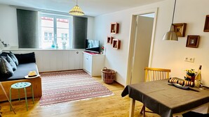 Un espace de vie moderne comprenant un canapé, une table à manger et un coin cuisine.