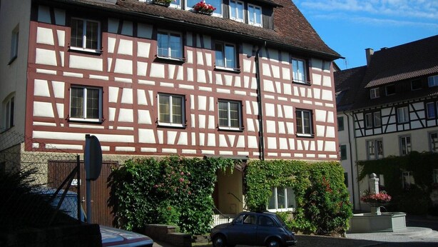 Un bâtiment traditionnel à colombages, avec une voiture garée devant.