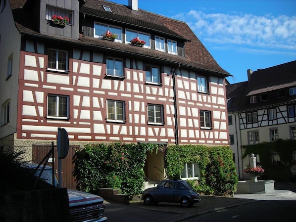 A traditional half-timbered building with a car parked in front.