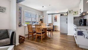 Een moderne keuken met houten meubels, een eettafel en een inbouwoven.