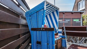 Een blauw-witte streepstructuur met een bank en een tafel, vermoedelijk een zithoek.