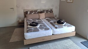 Un lit double avec une couvre-lit à motifs, deux oreillers, une table de chevet avec une lampe et un tableau encadré au mur.
