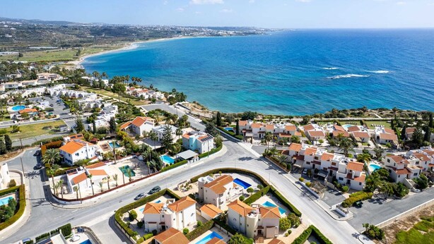 Zona residencial costera con casas, calles y una playa.