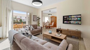 Una sala de estar moderna con sofá, mesa de centro y comedor.