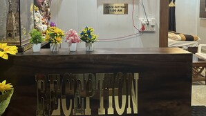 A reception desk with a sign for Ganga Godawari Guest House, including a phone number and address. - Ganga Godawari Guest House (Varanasi)