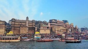 A riverfront with historic buildings and boats. - Ganga Godawari Guest House (Varanasi)