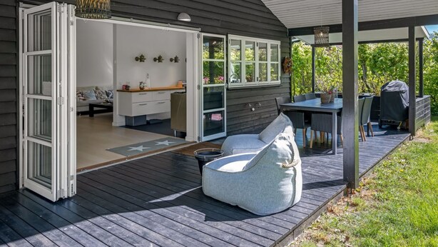 Una terraza abierta con comedor, cocina integrada y una zona de estar acogedora.