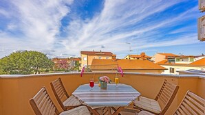 A rooftop terrace with a table and chairs, a clear sky, and buildings in the background. - Apartment near Pula with Sea View Balcony (Medulin)