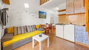 A compact living space with a sofa, dining table, and kitchenette. - Apartment near Pula with Sea View Balcony (Medulin)