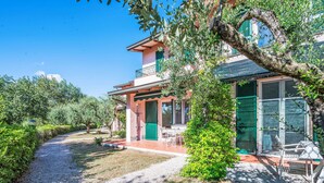 A house with a gravel driveway, a covered patio, and a view of the surrounding greenery. - La Rocca by Interhome (Magione)