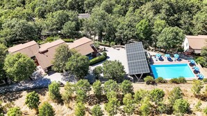 An aerial view of a residential area with multiple houses, a swimming pool, and surrounding greenery. - La Rocca by Interhome (Magione)
