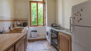 A compact kitchen with a washing machine, oven, and a refrigerator. - Farmhouse in Giroux near Forest & Lake (Giroux)
