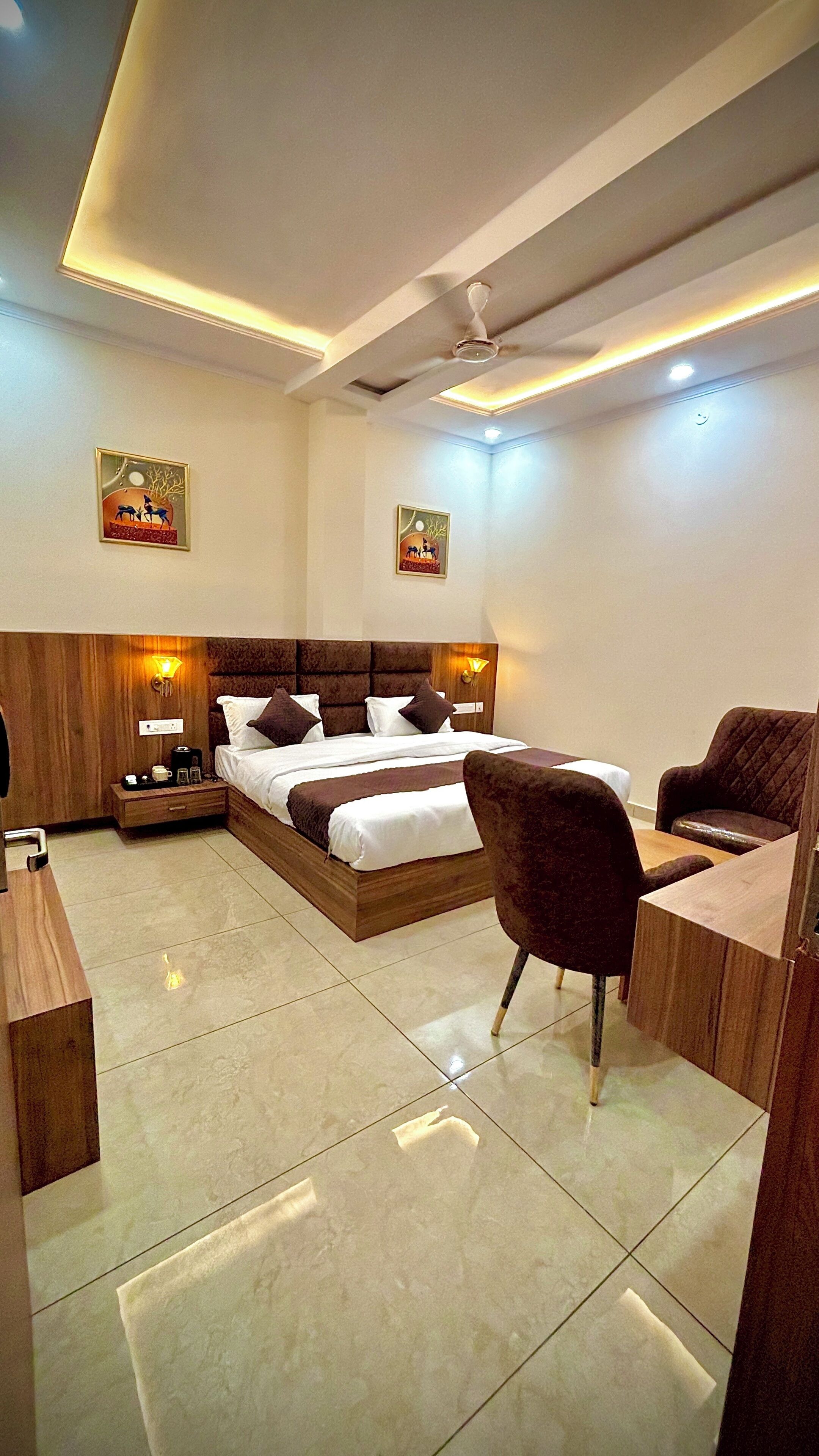 A modern hotel room with a large bed, bedside tables, a desk, and a chair.