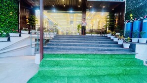 A staircase leading to a building with a green artificial grass landing area. - The Castle View (Haridwar)