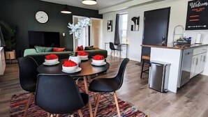 En moderne stue med spiseplads, et køkken og et lille kontor.