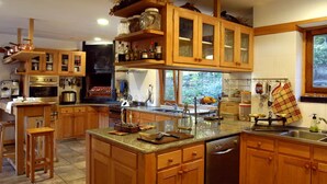 A spacious kitchen with wooden cabinets, a large island, and a built-in oven.