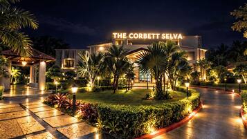 A hotel entrance with a well-lit pathway, palm trees, and a sign reading 'THE CORBETT SELVA'.