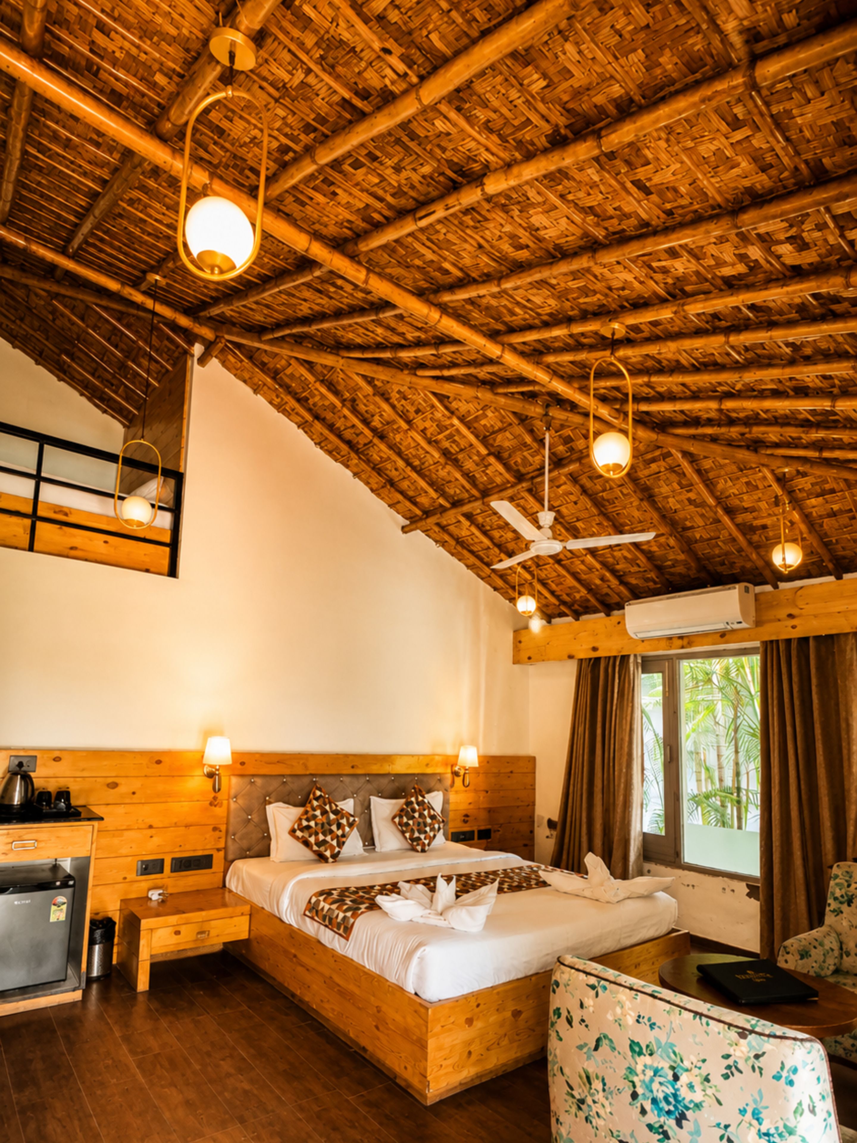 A wooden-framed room with a bed, bedside tables, a desk, and a chair.