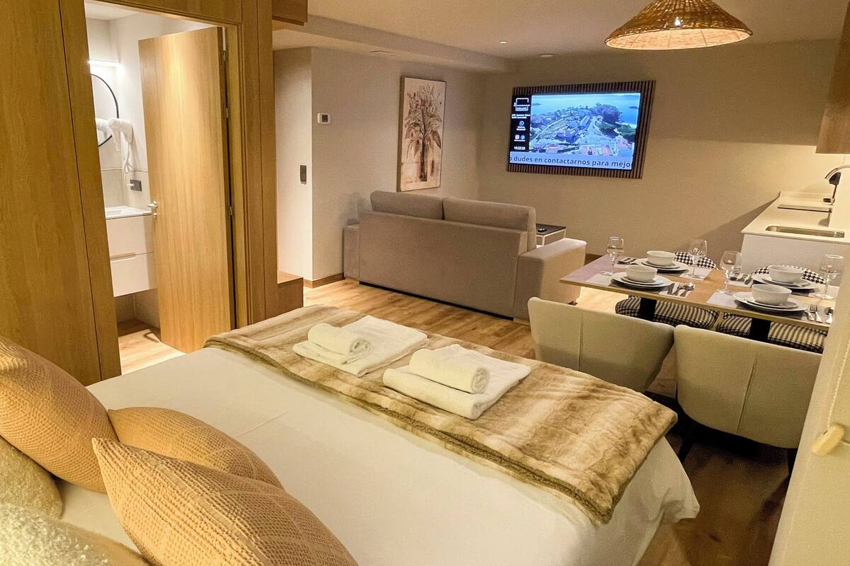 Une chambre d’hôtel comprenant un lit, un canapé, une télévision et un coin repas.