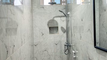 Een douche, handdoeken, zeep, toiletpapier