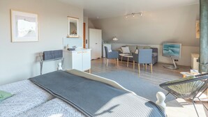 Ein modernes Hotelzimmer mit Bett, Schreibtisch, Stuhl, Fernseher und Bad.