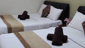 Habitación de hotel con dos camas, cada una con una colcha a rayas blancas y marrones y almohadas.