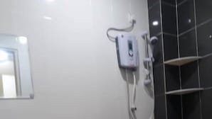 Un baño moderno con inodoro, lavamanos y cabina de ducha.