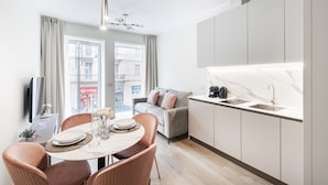 A modern apartment with a dining area, kitchen, and living space. - Easylife - Duomo Deluxe Apartments #5 (Milano)