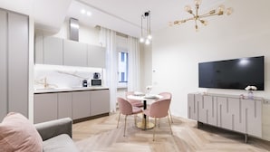 Une cuisine moderne avec un coin repas, un canapé et un téléviseur.