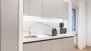 Une cuisine moderne dotée d’un plan de travail en marbre, d’une machine à café et d’un four à micro-ondes.