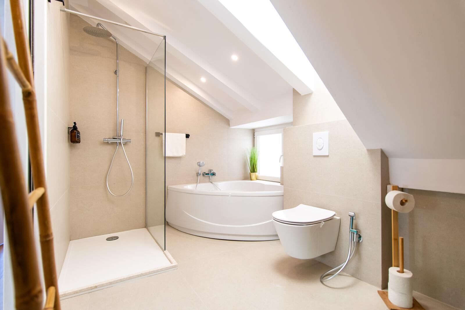 A modern bathroom with a glass-enclosed shower, a freestanding bathtub, and a toilet.