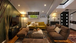 Un salon moderne avec un canapé jaune, des fauteuils marron et un tapis à motifs.
