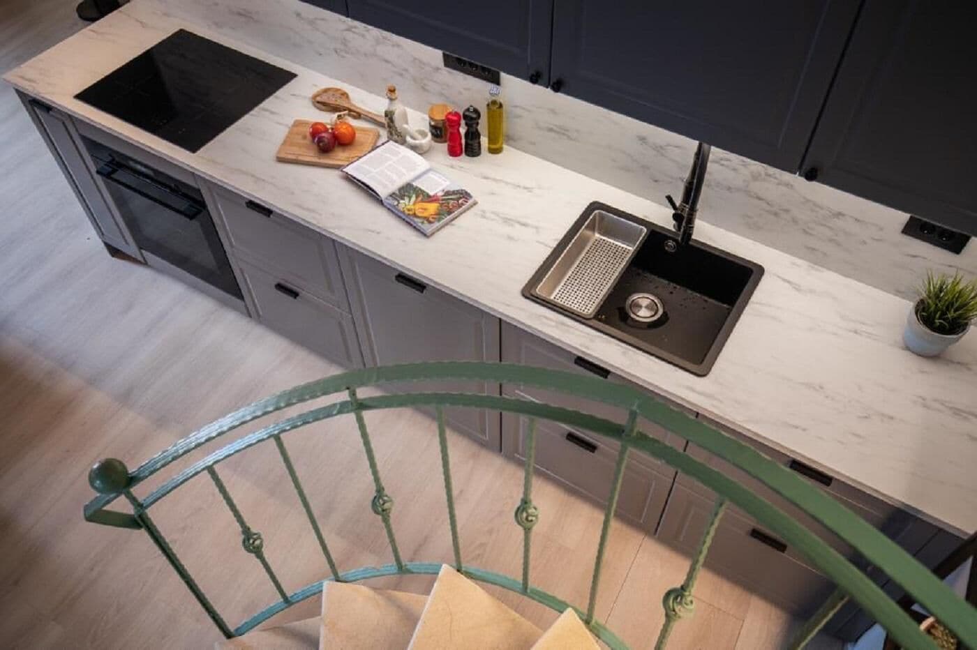 Una cocina moderna con estufa integrada, un fregadero y una tabla de madera con verduras.