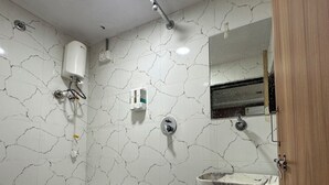 Une salle de bain équipée de toilettes, d’un lavabo, d’un miroir et d’un seau.