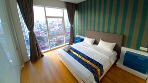 A bedroom with a large bed, a view of the city through a window, and striped wallpaper. - WELL-SHAPED Suites At PLATINUM KLCC (Kuala Lumpur)