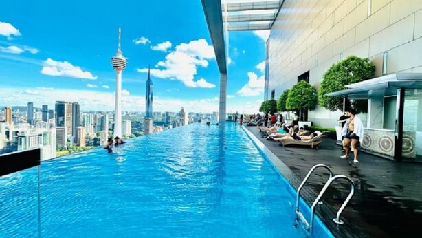 A rooftop infinity pool with a city skyline view, including a prominent tower. - WELL-SHAPED Suites At PLATINUM KLCC (Kuala Lumpur)
