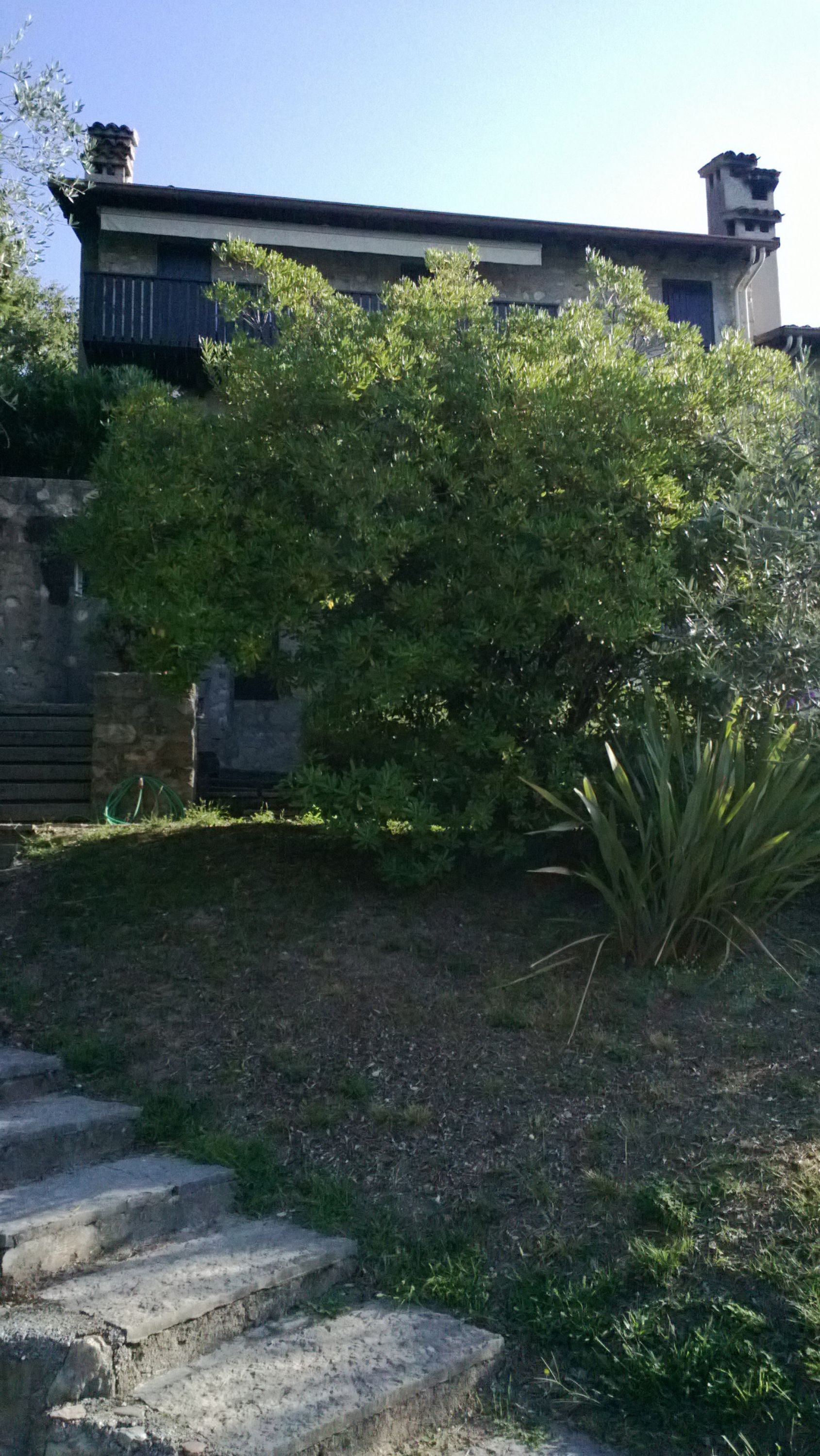 A stone staircase leading up to a building with a flat roof and a chimney.