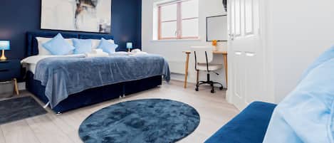Un dormitorio moderno con una cama, un escritorio y una silla.