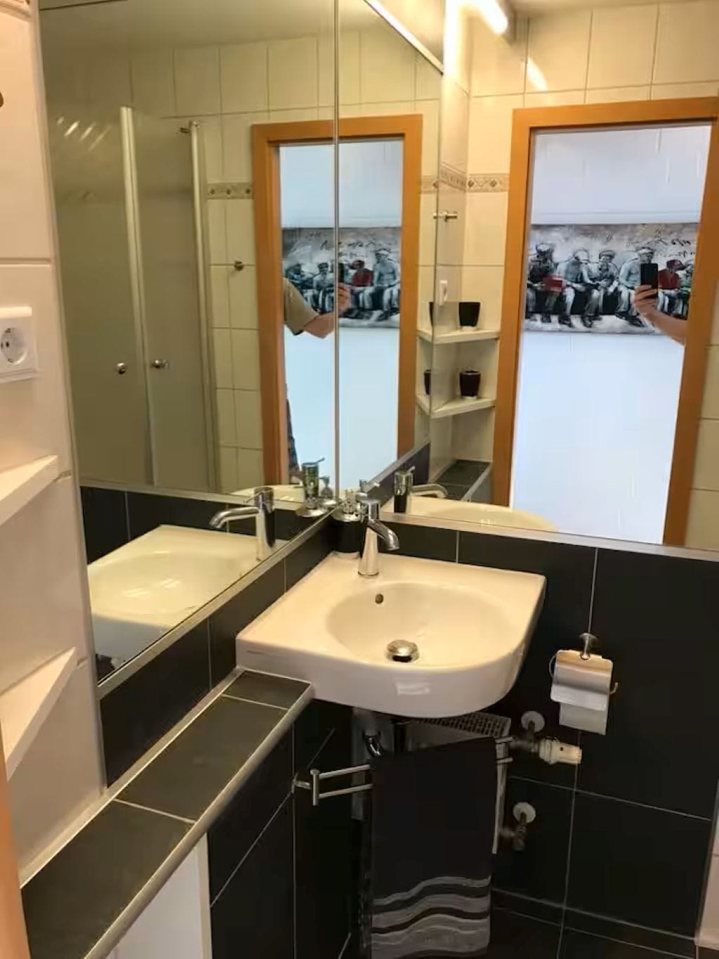 A bathroom with two sinks, a mirror, and a towel rack.