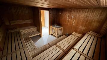 Un sauna avec des bancs en bois et un petit chauffage.