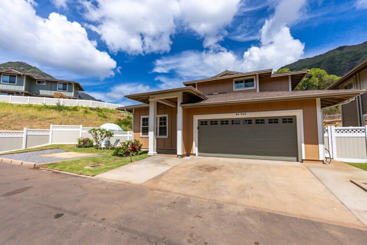 A two-story house with a garage, a driveway, and a well-maintained lawn.