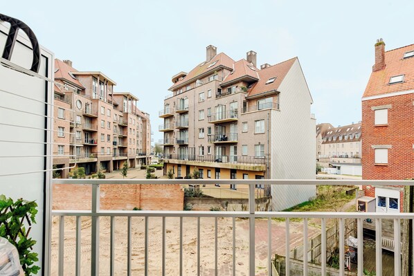 A residential building with multiple balconies, a courtyard, and a brick facade.